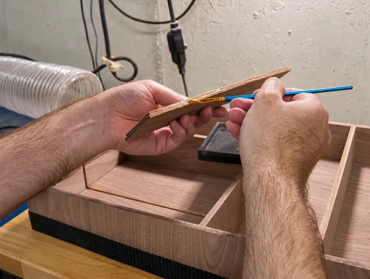 Applying glue to a walnut organizer joint with a small art brush